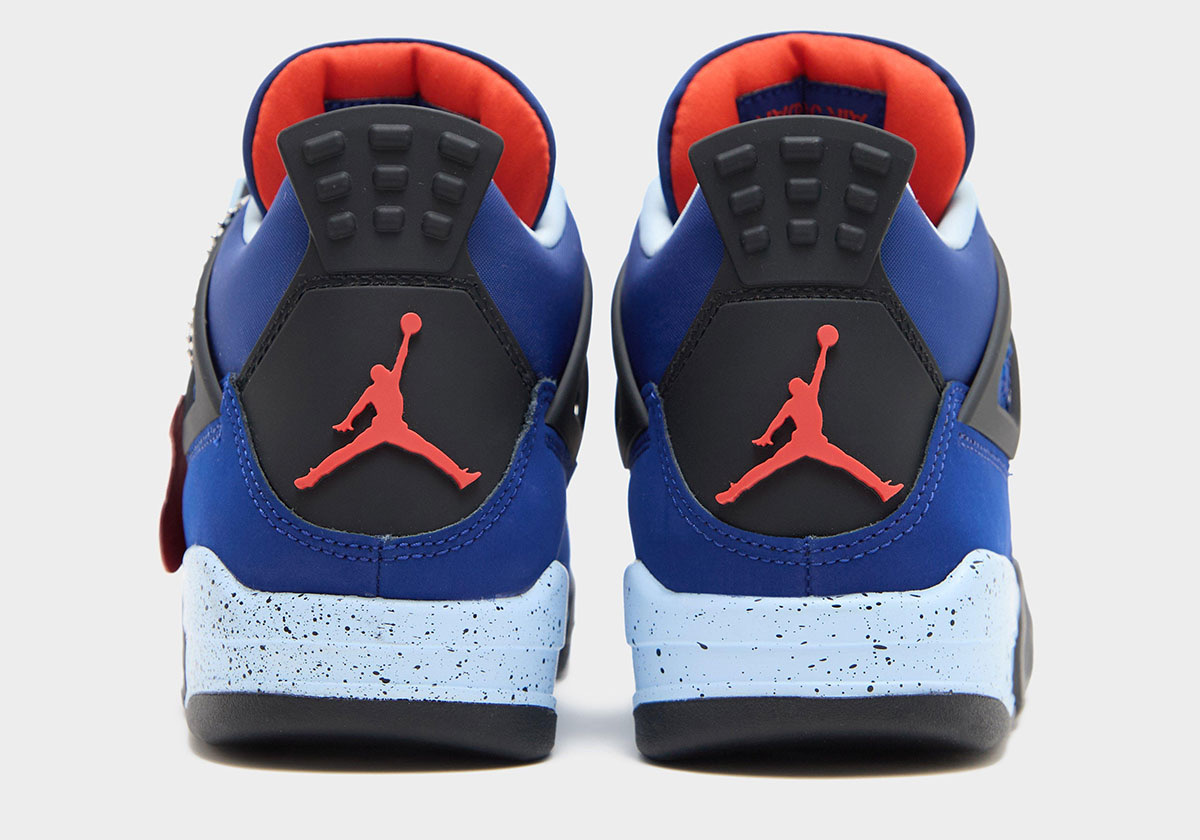 Talones del Air Jordan 4 Deep Royal Blue sobre fondo gris claro, con la pestaña negra, el Jumpman rojo, la entresuela celeste moteada y el interior en rojo