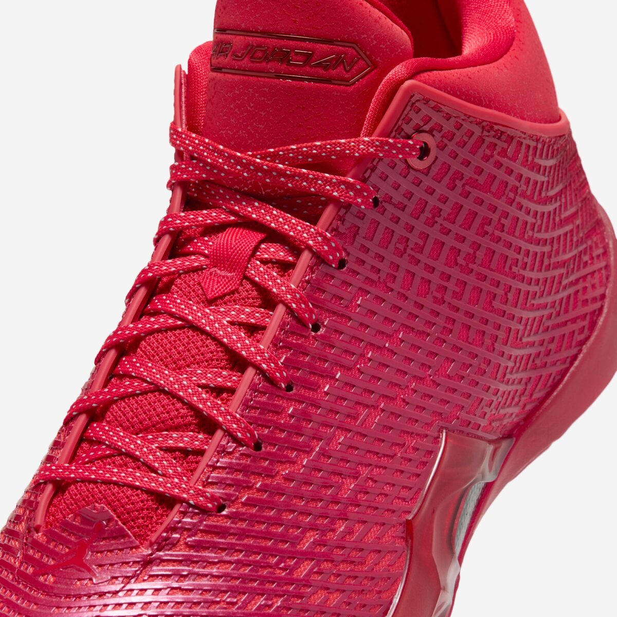 Primer plano de la capellada del Air Jordan 41 Ruby con la malla en relieve, los cordones jaspeados y la placa Air Jordan en la lengüeta