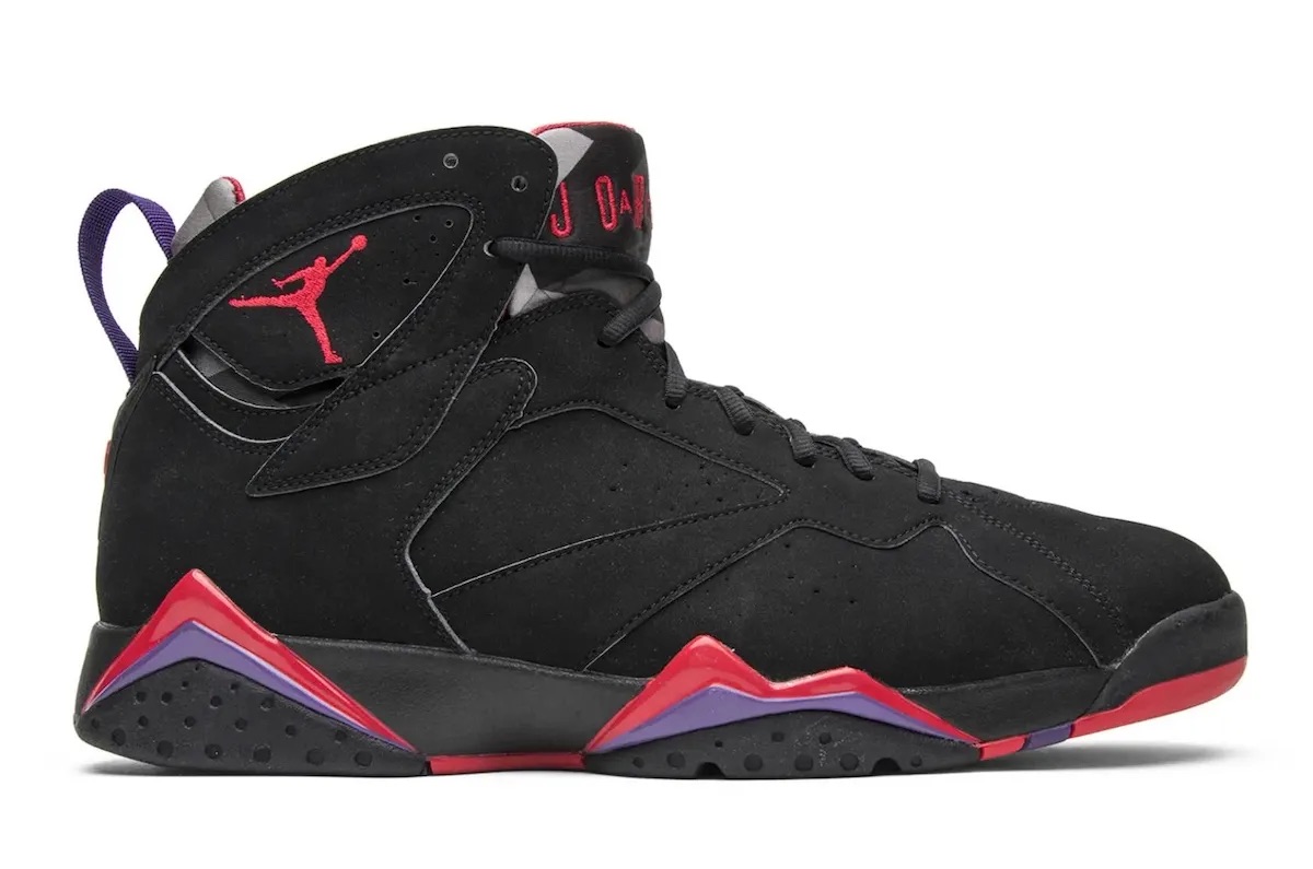 Foto de archivo: Air Jordan 7 Playoffs de la edición 2012 de perfil sobre fondo blanco, con upper de nubuck negro, Jumpman rojo, lengüeta con la inscripción Jordan en rojo y dientes rojos y violetas en la mediasuela