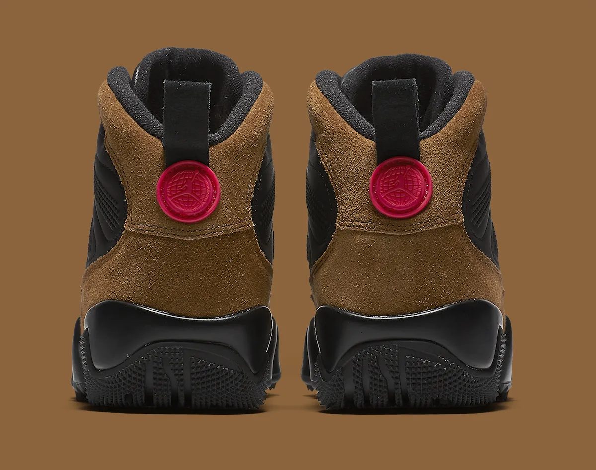 Talones del Air Jordan 9 Boot Olive sobre fondo marrón, con la gamuza verde oliva, el medallón rojo con el logo y la suela negra con tacos