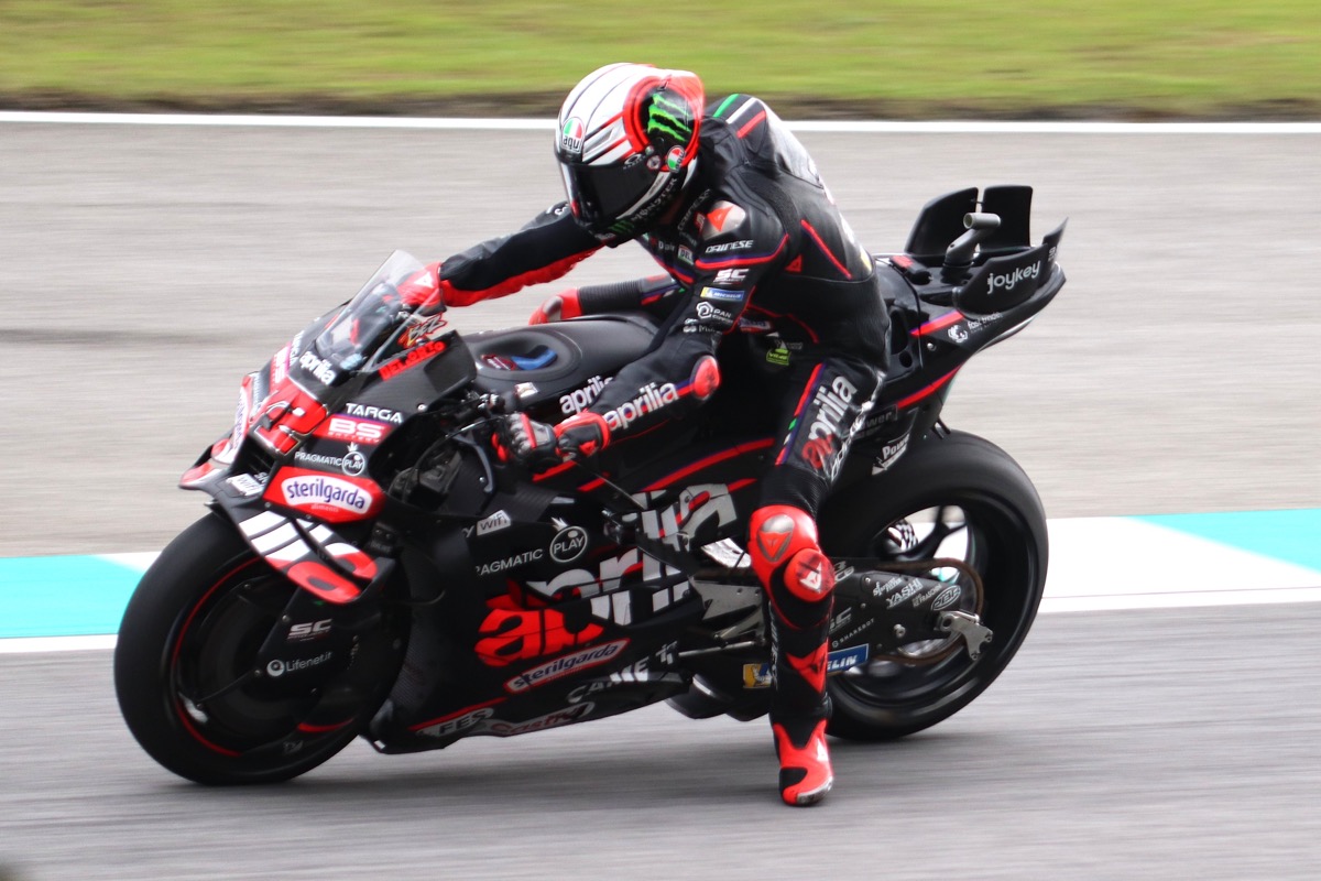 Foto de archivo: Marco Bezzecchi, con casco blanco y rojo, inclina la Aprilia negra y roja en una curva con pianos celestes y blancos