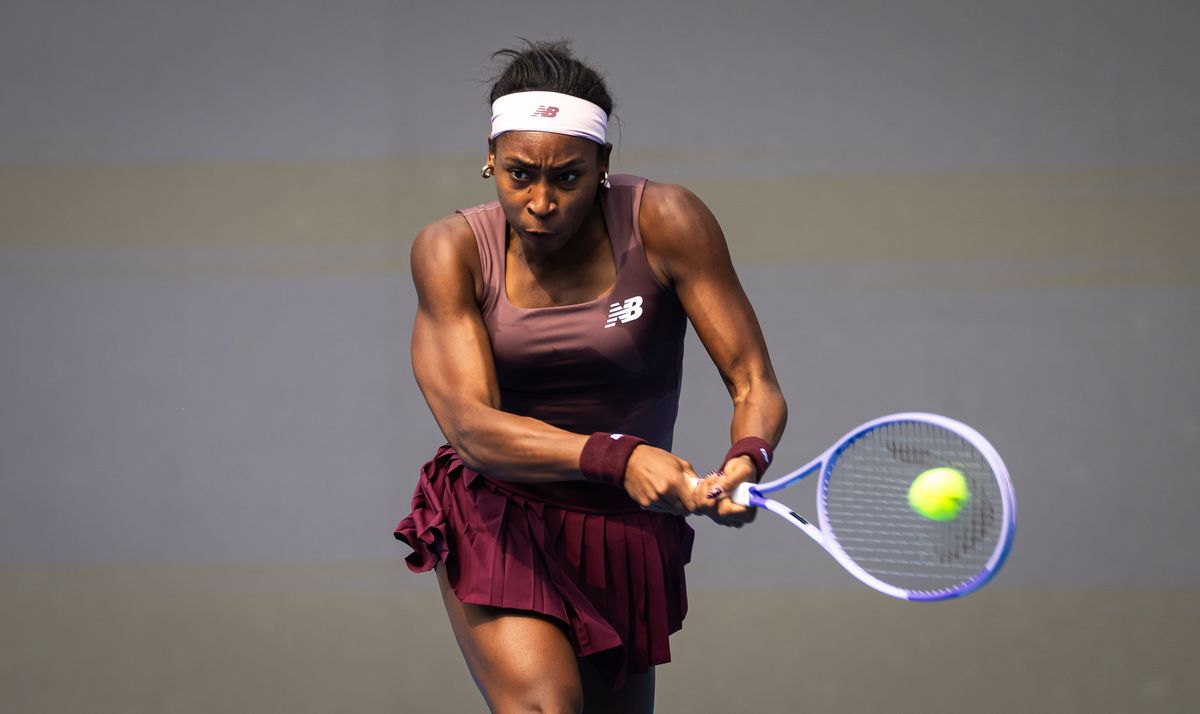 Coco Gauff, con vincha blanca y vestido bordó, pega un revés a dos manos en el China Open 2026