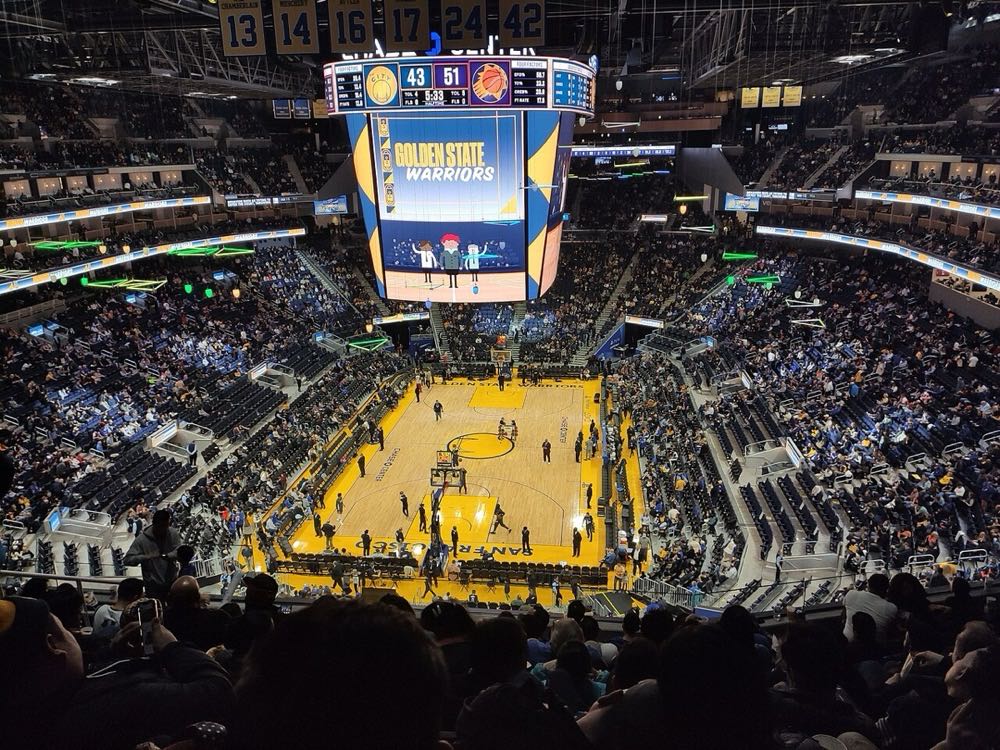 Foto de archivo: vista desde lo alto del Chase Center de San Francisco durante un partido de los Golden State Warriors, con la cancha de madera, la pantalla gigante en el centro y las tribunas llenas