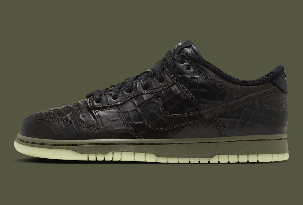 Nike Dunk Low Shibuya Halloween de perfil sobre fondo verde oliva, con upper de cuero negro texturado tipo cocodrilo, mediasuela verde oliva y suela verde clara