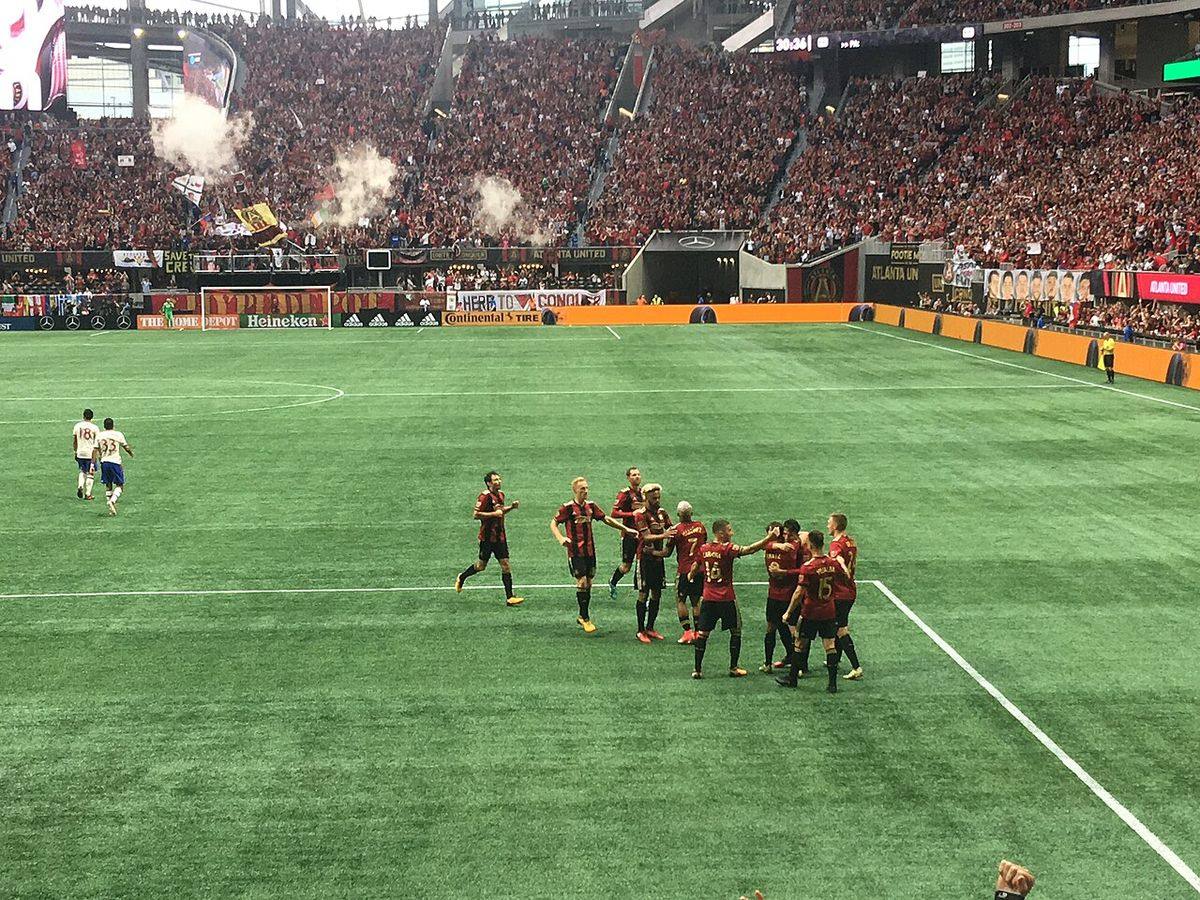 Jugadores de Atlanta United, con la camiseta roja y negra, festejan un gol en el Mercedes-Benz Stadium con las tribunas llenas; foto de archivo de octubre de 2017 (foto: Eric.Jason.Cross, Wikimedia Commons, licencia CC BY-SA 4.0)