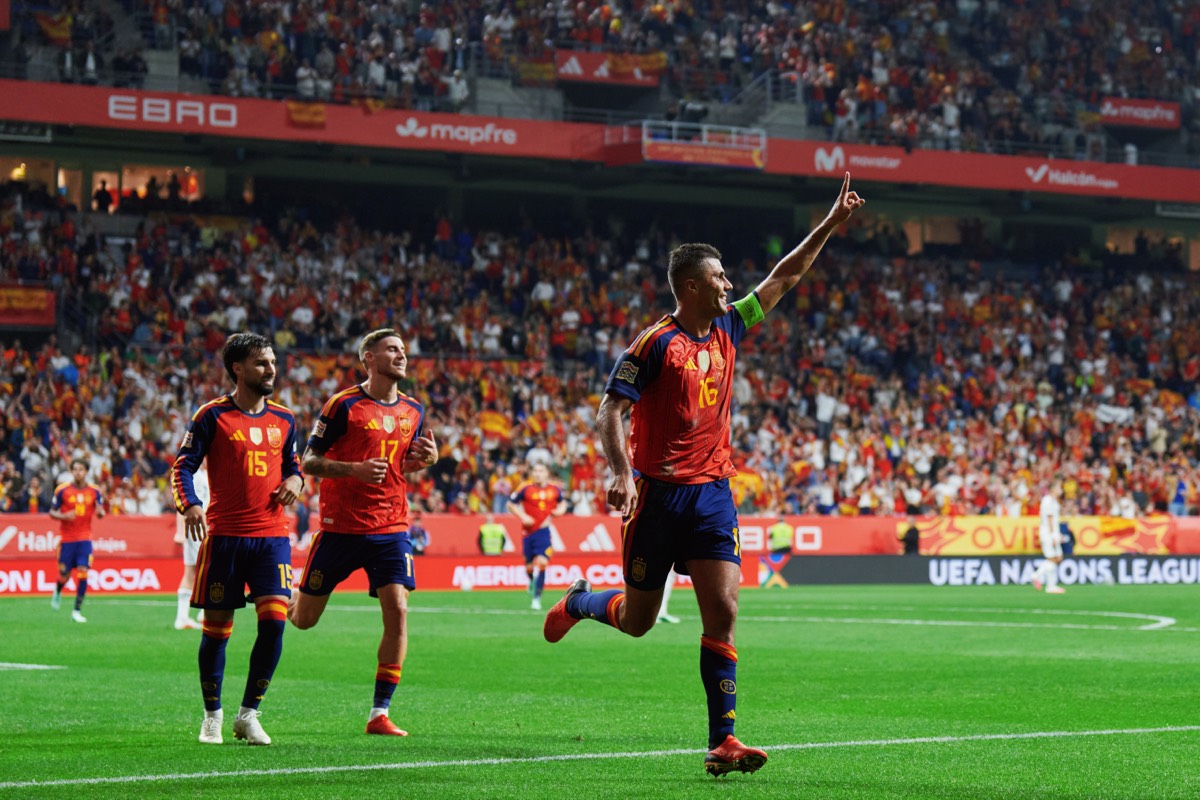 Rodri, con la cinta de capitán y el número 16, festeja su gol con el brazo en alto, seguido por dos compañeros de España en el Nuevo Carlos Tartiere