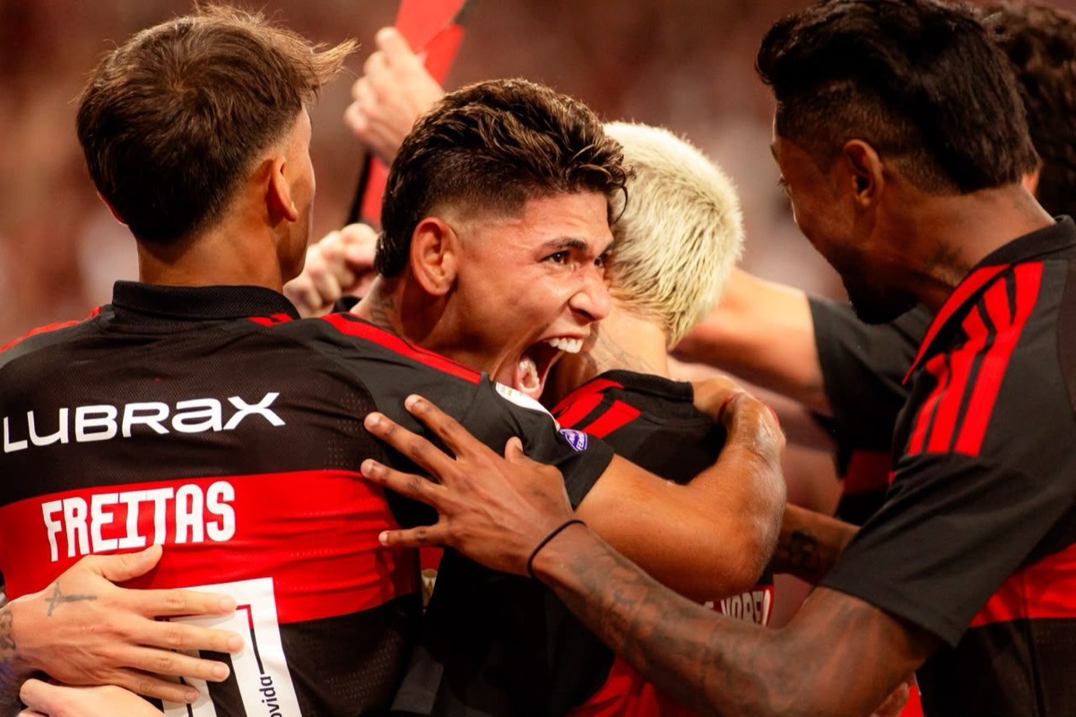Carrascal, en el centro, grita el gol abrazado por sus compañeros del Flamengo; a la izquierda se ve de espaldas la camiseta del argentino Joaquín Freitas (foto: Adriano Fontes / CRF)