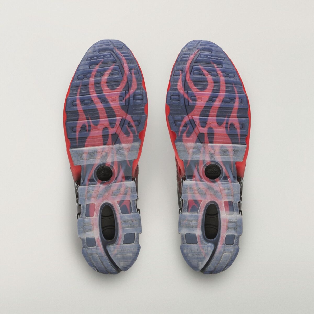 Suelas del HELLSTAR x adidas Megaride S2 Red/Black, translúcidas en tono azulado, con llamas rojas que recorren toda la planta y el logo de adidas en el centro