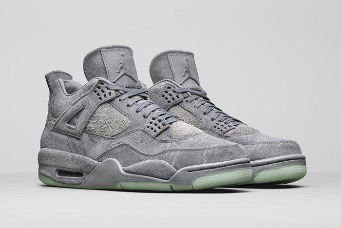 Foto de archivo: KAWS x Air Jordan 4 Cool Grey de 2017 en foto oficial de producto, vista de tres cuartos sobre fondo gris claro, con gamuza gris, bordados de las manos de KAWS en el upper y suela translúcida verde agua