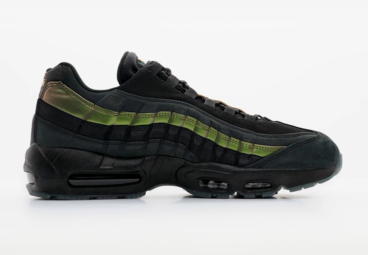 Kyle Wilson x Nike SB Air Max 95 negro de perfil sobre fondo gris claro, con malla y gamuza negras, una franja verde metalizada en los paneles laterales que se vuelve dorada hacia el talón y suela negra