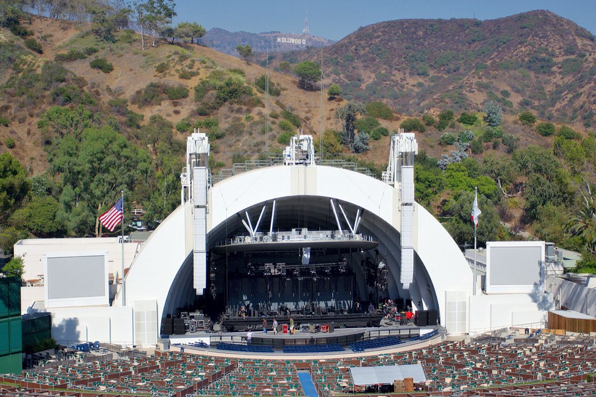 El Hollywood Bowl de Los Ángeles de día, con su escenario en forma de arcos concéntricos, la platea vacía y el cartel de Hollywood en los cerros del fondo. Foto: Matthew Field, Wikimedia Commons, licencia CC BY-SA 2.5