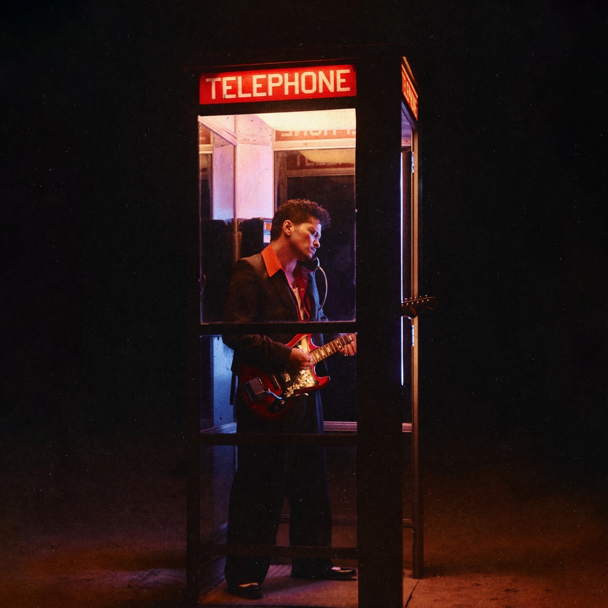 Portada del single Dance With Me de Bruno Mars: el cantante toca una guitarra eléctrica roja dentro de una cabina telefónica iluminada de noche