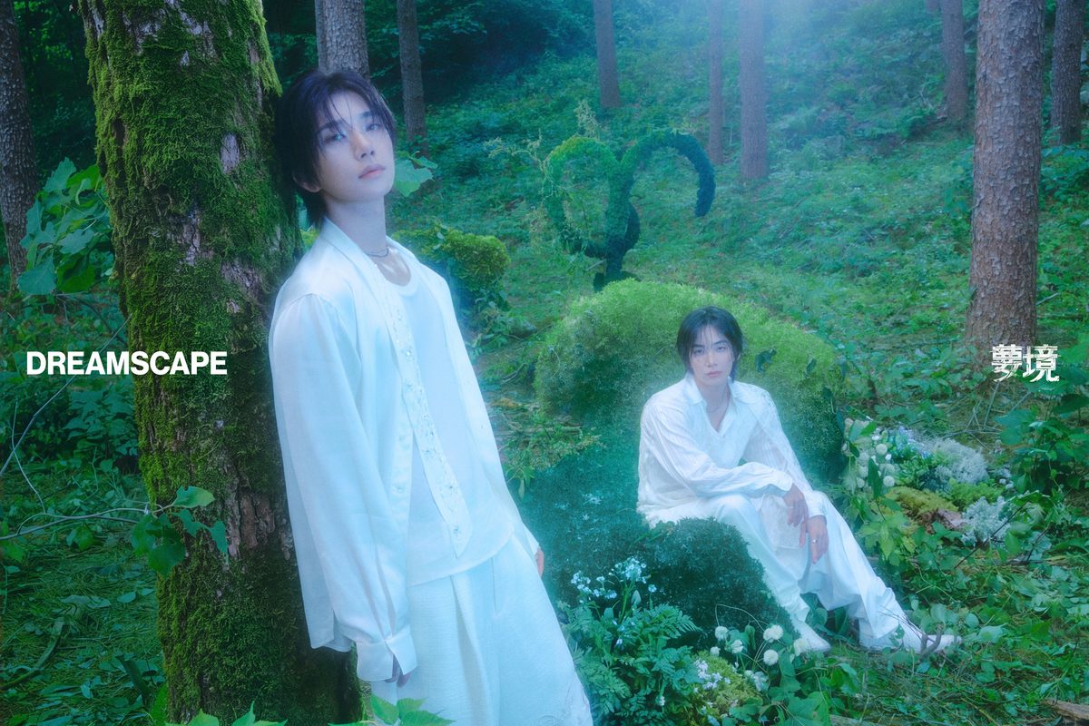 Foto conceptual oficial de «DREAMSCAPE»: Jeonghan y Joshua vestidos de blanco en un bosque de árboles cubiertos de musgo, uno de pie junto a un tronco y el otro sentado entre helechos, con el título del disco en letras blancas