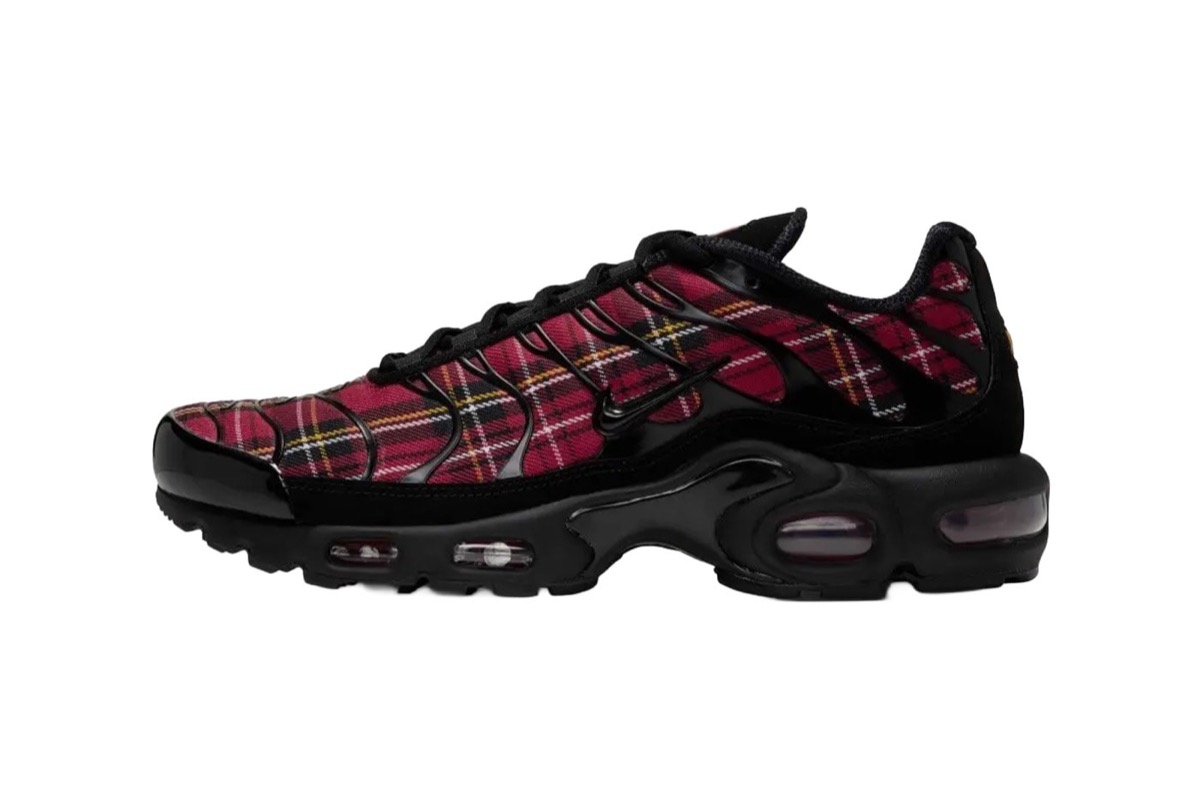 Nike Air Max Plus de mujer del Plaid Pack de perfil sobre fondo blanco, con el upper en tela escocesa roja con líneas negras, blancas y amarillas bajo la jaula negra y la cámara de aire negra