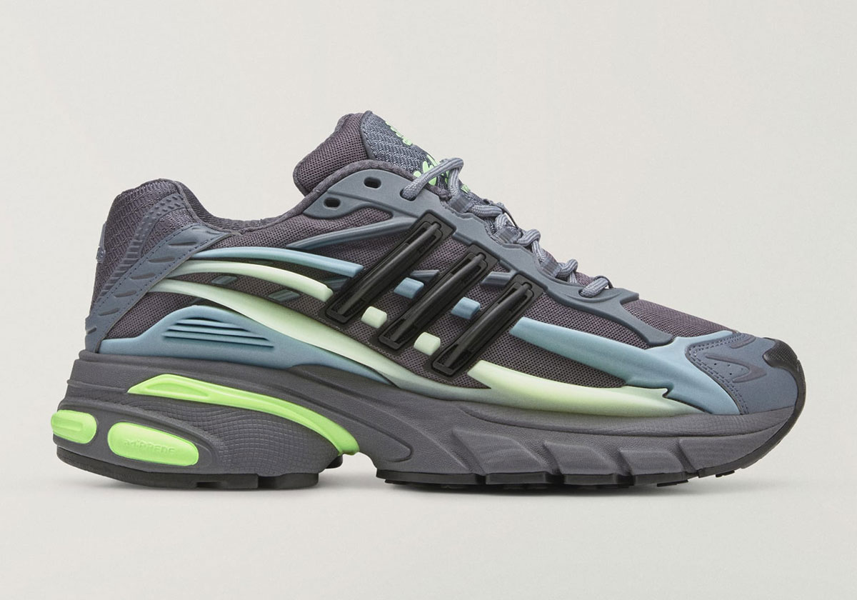 Pharrell x adidas Adistar Jellyfish Storm de perfil lateral con malla gris oscura, Three Stripes negras, overlays celestes y verde pálido y mediasuela gris con acentos volt