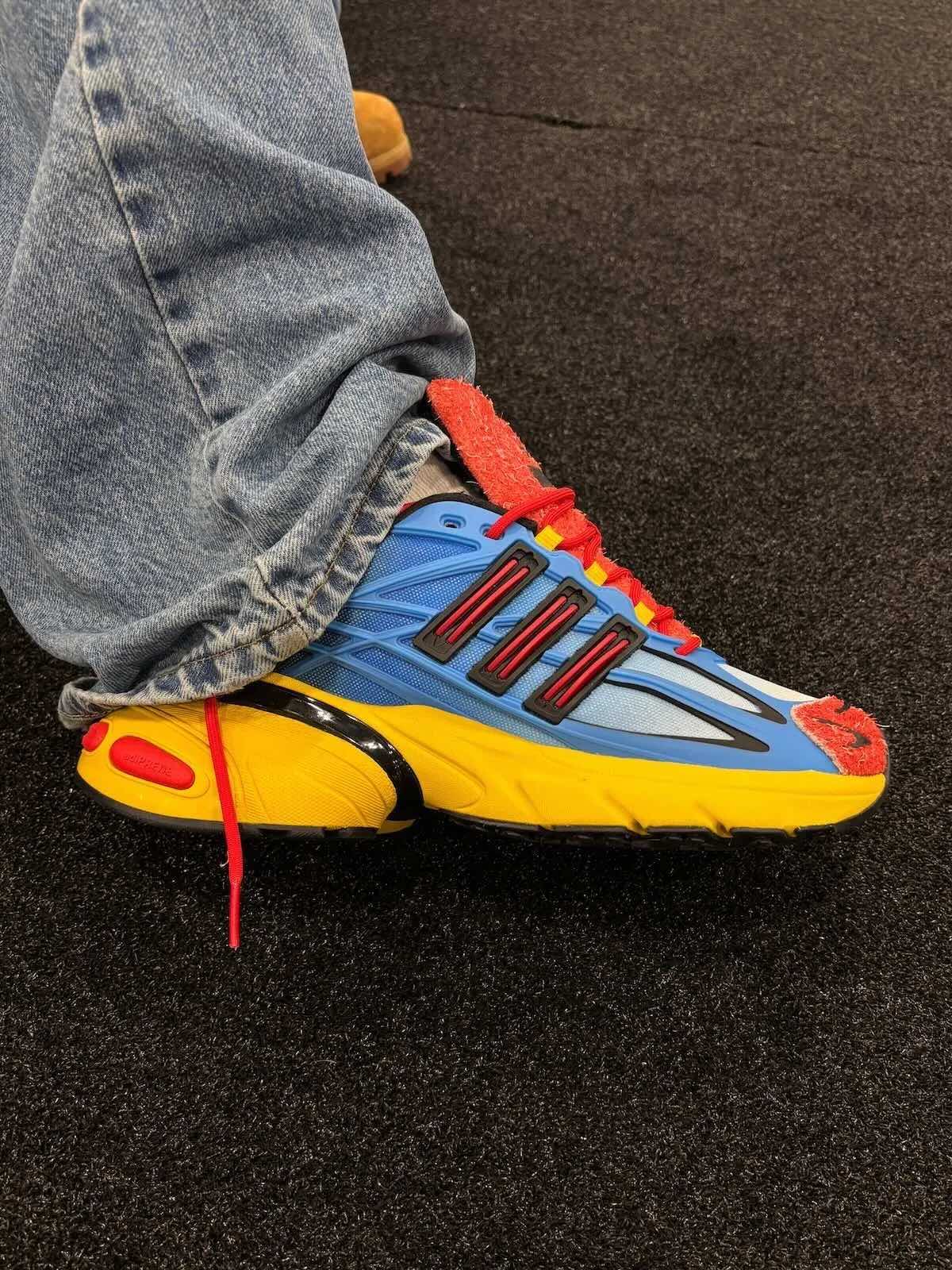 adidas Adistar XLG 2.0 Mandrill de Shake James puesta, con malla azul en degradé, tres tiras negras con detalle rojo, gamuza peluda roja y mediasuela amarilla